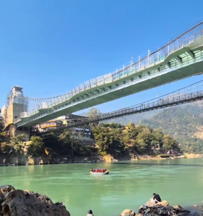 People walking on transparent glass walkway of Bajrang Setu Glass Bridge Rishikesh over Ganga